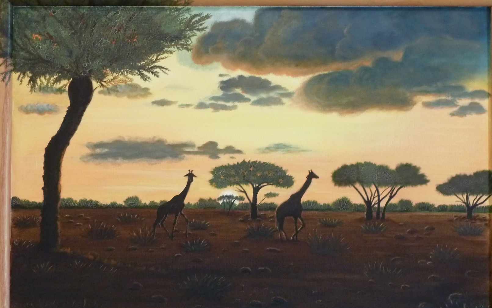 Giraffen und Akazien als Silhouetten in der Savanne vor einem warmen Abendhimmel.