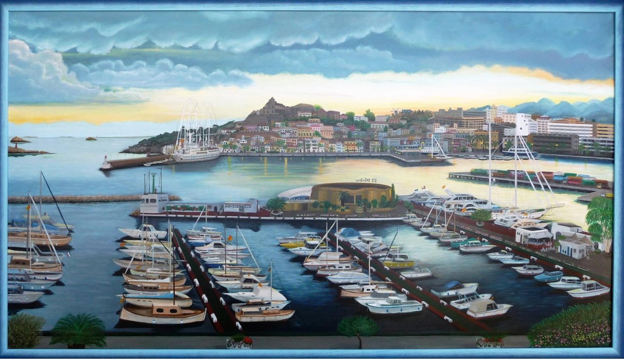 Panoramischer Blick auf einen mediterranen Hafen mit Booten und Altstadt im Abendlicht.
