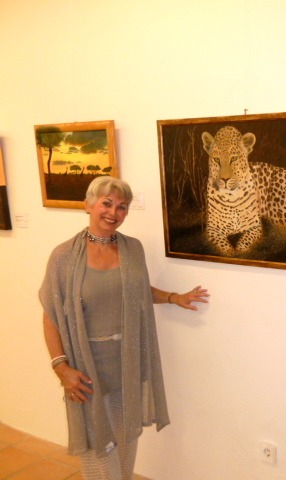 Bricia Lorenz neben ihrem Gemälde eines Leoparden
